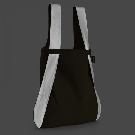 Bolsa-mochila plegable color negra con asas reflectantes como bolso